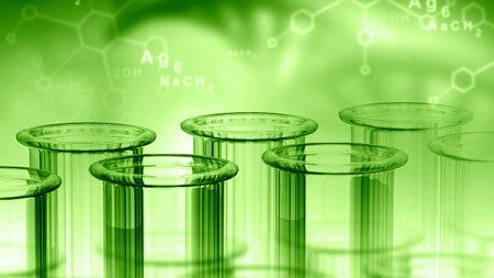 Beakers against a green backdrop with chemical formulas