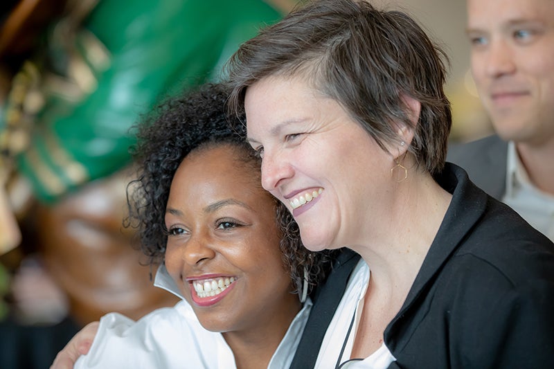Photo of two women executive MBA students hugging and smiling