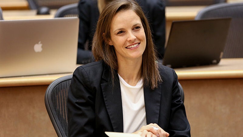 A femaie Oregon MBA student smiles while in class in a Lillis classroom