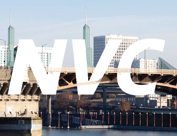 The letters NVC in white against a background of the Portland city skyline