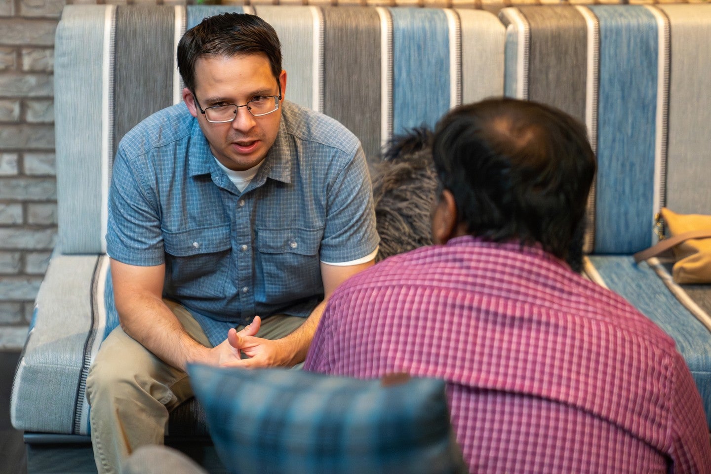 Two men sitting facing each other having a conversation.