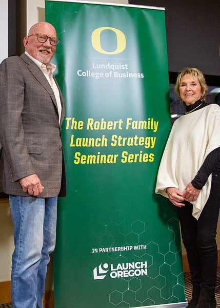 The Robert Family poses in front the the seminar series banner bearing their name