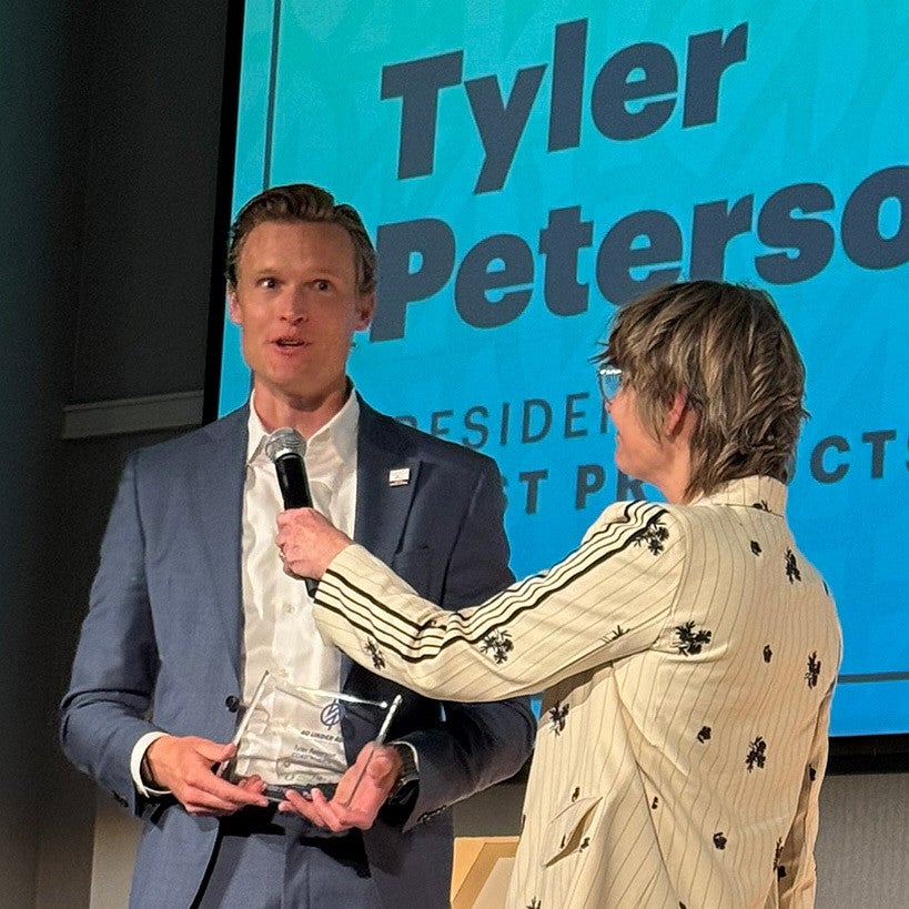 Tyler Peterson '09 is interviewed onstage at Portland Business Journal's 40 under 40 awards luncheon.