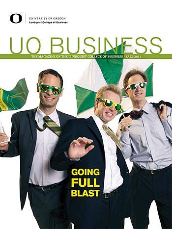 Cover of the issue featuring three men in suits being blown by the wind with ties flying, umbrellas inside out and flags waving, with the words "Going Full Blast"