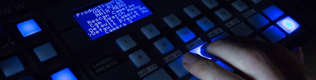 Close up of a hand over a backlight control panel of the technology available in the Insights Research Lab