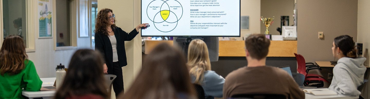 An instructor leads attending students in a training workshop