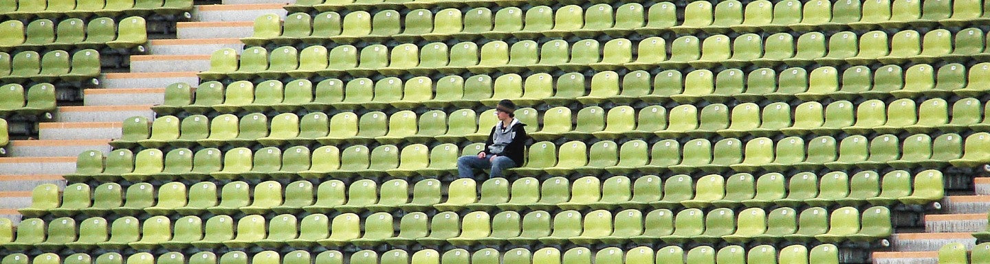 A fan sits alone in a stadium