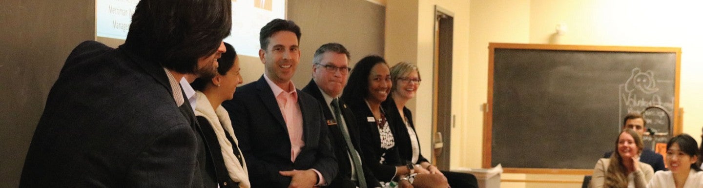 Panelists smile and laugh during a panel discussion