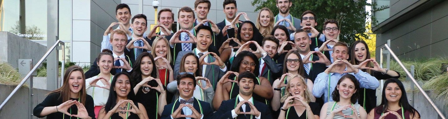 A group of business honors students make the Oregon "O" sign