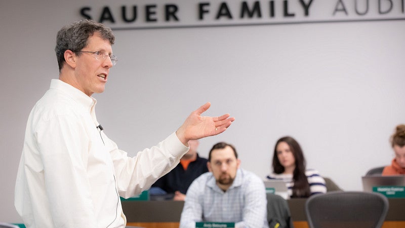 One faculty member giving a lecture to a classroom full of Oregon Executive MBA students.