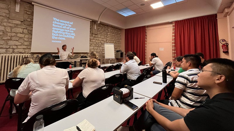 MBA students seated in a classroom, listening to a presentation.