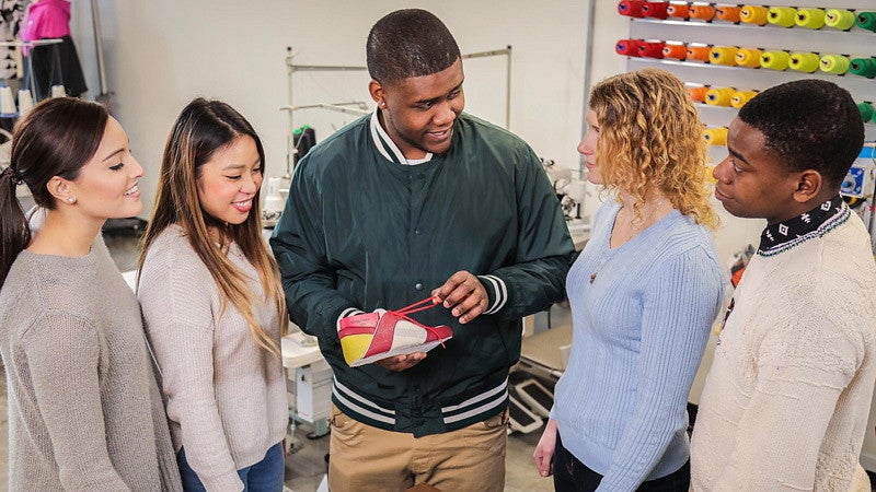 Five SPM students discuss shoe making while in the program's innovation lab in Portland