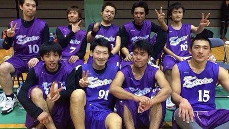 SPM student Saito (bottom row, second from left, number 91) with his basketball team in Japan. All members sitting in a gym with blue jerseys.