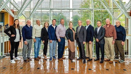 Lundquist College of Business's Board of Advisors standing in a line for a group photo.