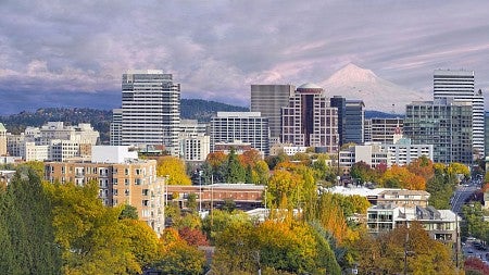 Photo of the Portland skyline on a sunny day with a snowy Mt Hood in the distance
