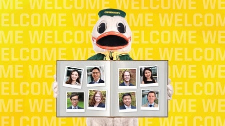 The UO Duck mascot holds out a book (upon which are placed eight photos of new faculty members, scrapbook-style) to the viewer.