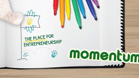 The hand of the UO Duck mascot points to a scrapbook page bearing the word "Momentum" and a drawing of a flag with the text "The place for entrepreneurship."