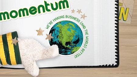 The hand of the UO Duck mascot points to a scrapbook page bearing the word "Momentum" and a sticker of the earth surrounded by the text "We're making business (and the world) better!"