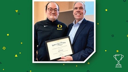 Accounting professor Jaewoo Kim (left) is presented with the Stewart Distinguished Faculty Award by Lundquist College Dean Bruce Blonigen (right).