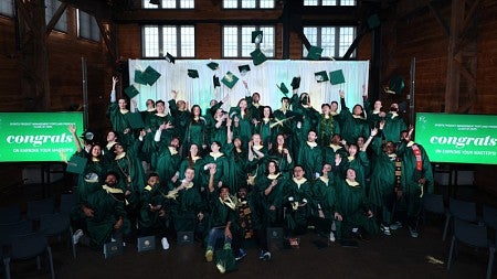 The Sports Product Management Class of 2025 throw their graduation caps in the air after commencement