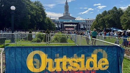 Attendees enjoy the Outside Festival on the lawn of a historic building
