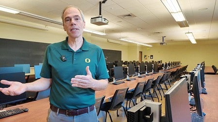 Lundquist College Dean Bruce Blonigen stand in a classroom filed with computers