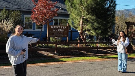 UO students Natalie Cohen and Julie Gomez stand outside the Westfir Lodge in Oakridge, Oregon