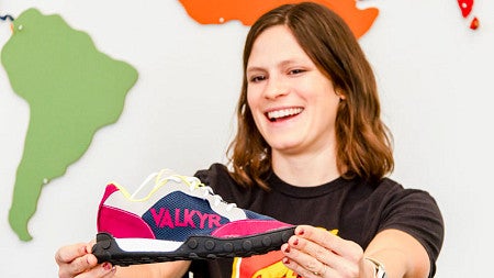 An SPM student holds a shoe design out in front of herself