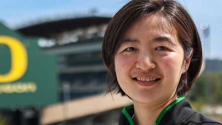 Alicia smiles while standing in front on Autzen Stadium.