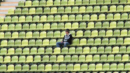 A fan sits alone in a stadium