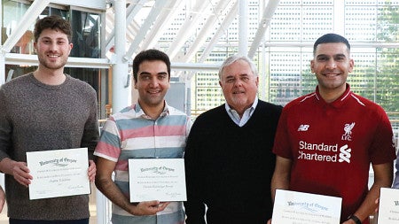 Roger Best poses for a photo with award-winning PhD students