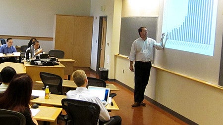 A full classroom during the conference watches the presenter