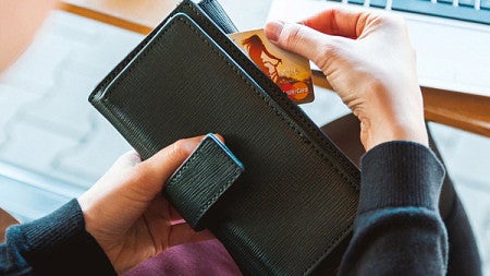 A person pulls a credit card out of their wallet
