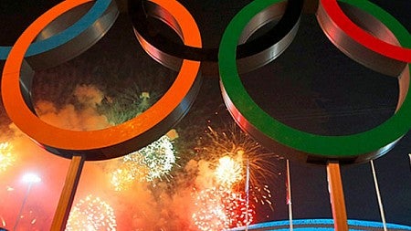 Olympic rings against a backdrop of fireworks