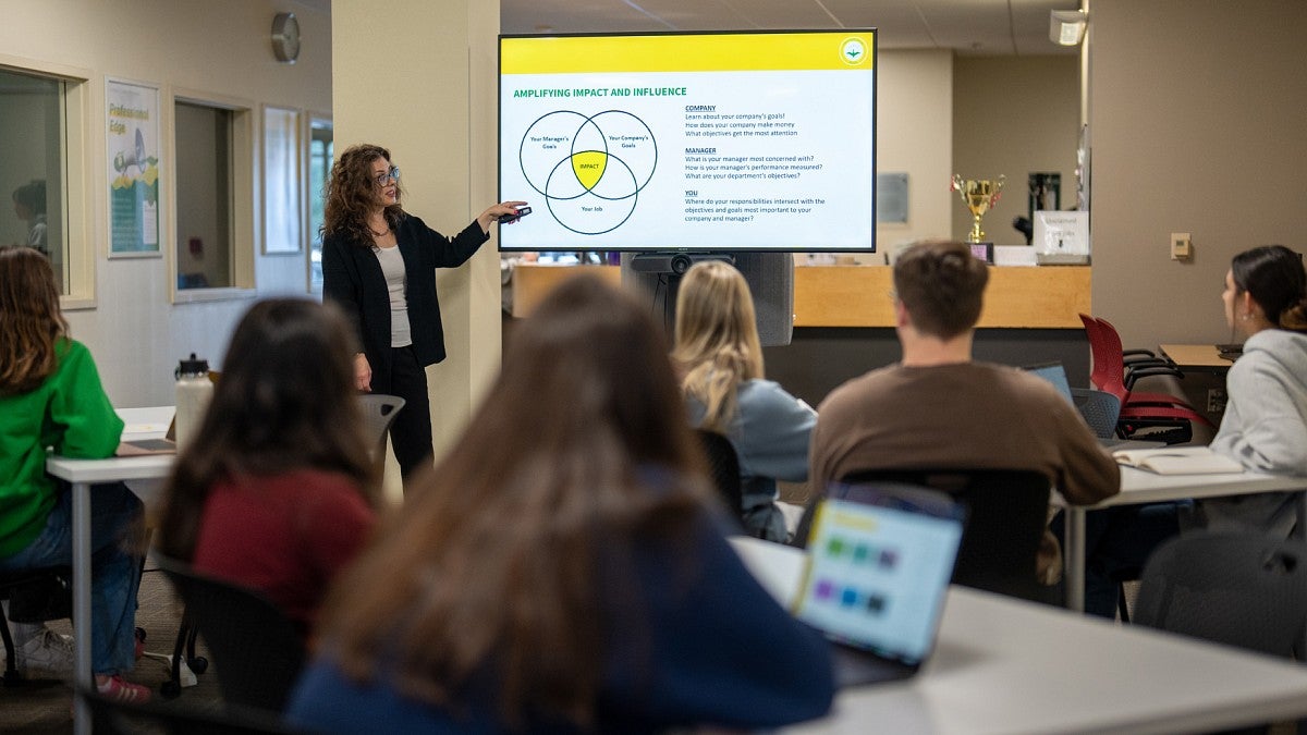 An instructor leads attending students in a training workshop