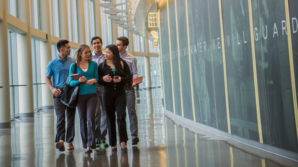 Warsaw Sports Marketing Center students walk in a group and talk at Matt Knight arena