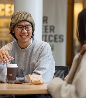 Two students enjoy coffee in the atrium