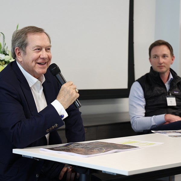 A close-up of two guest speakers sitting at the front of a classroom and excitedly speaking.