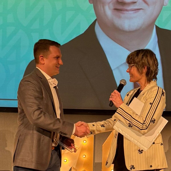 Josh Smith '14, MBA '26 onstage at Portland Business Journal's 40 under 40 awards luncheon.