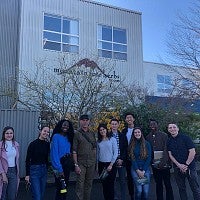 Members of the Net Impact group post for a group photo together outside of Mountain Rose Herbs headquarters in Eugene, Oregon